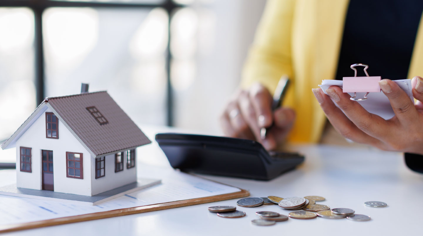 Conseiller d'agence immobilière présentant sur tablette les calculs de frais d'annulation à un jeune couple dans un espace de consultation